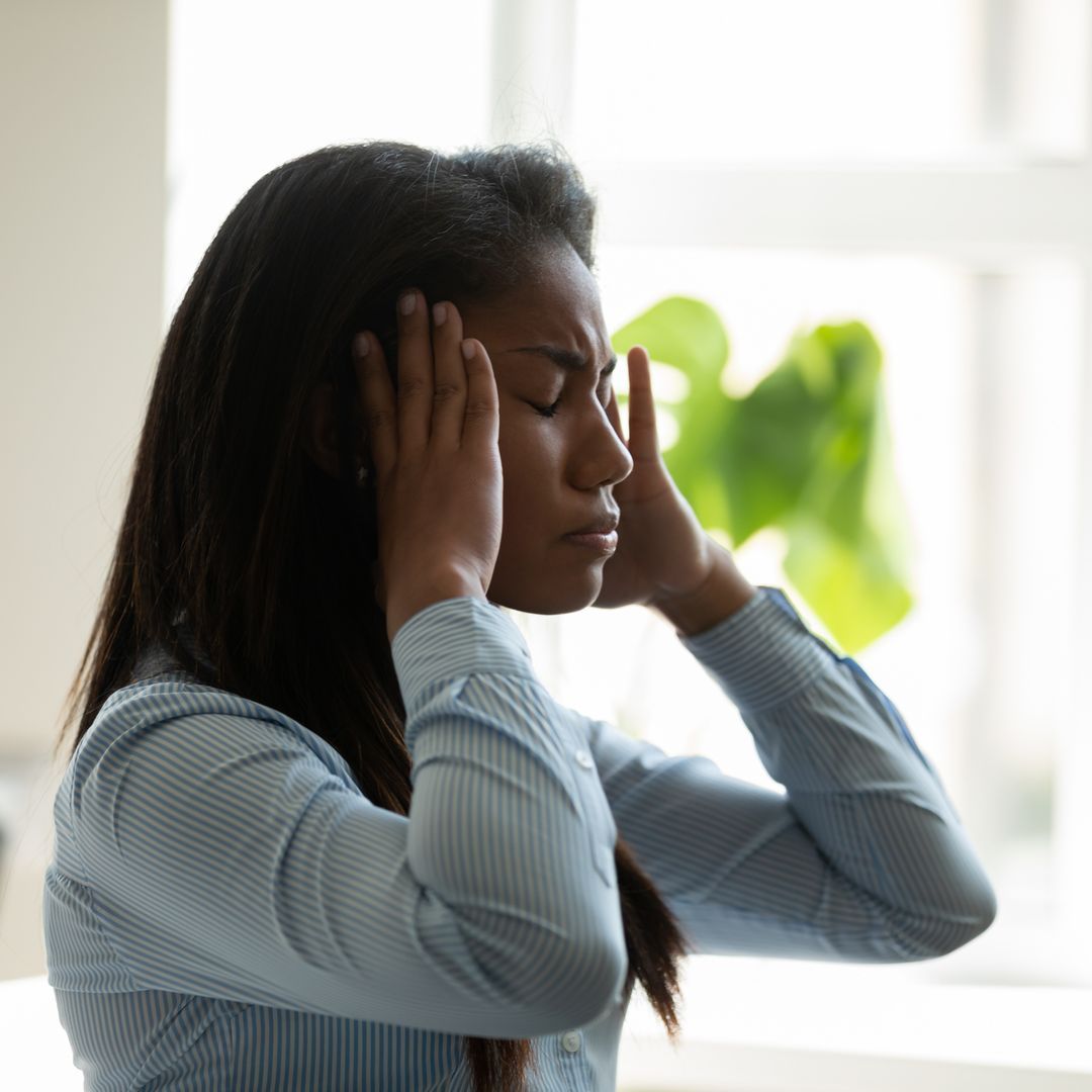Unhappy woman holding her head with her eyes closed