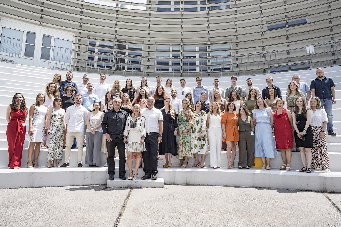 Genos research team standing outdoors on stadium-style steps.